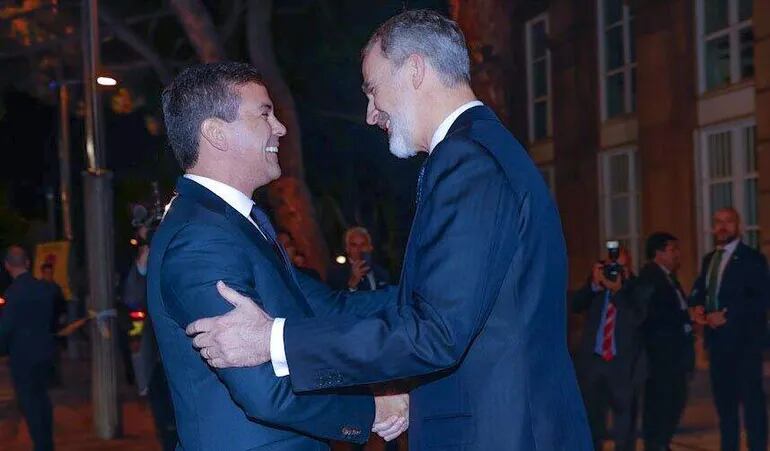 El presidente Santiago Peña (i) y el rey Felipe VI de España se saludan durante una cena el domingo en Barcelona.