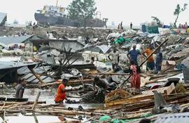 Personas buscan entre los escombros de casas destrozadas por el ciclón Sitrang en Chittagong, Bangladesh, este martes.