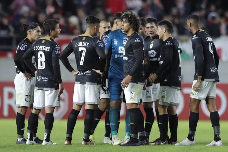 Los jugadores de Tacuary hablan antes de abandonar el campo de juego después de finalizar la primera parte del partido contra Estudiantes de La Plata por la segunda fecha de la fase de grupos de la Copa Sudamericana.