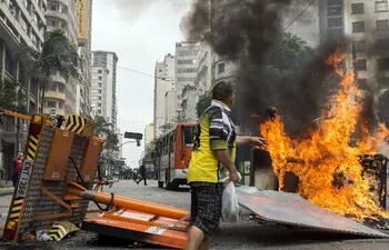 un-manifestante-lanza-basura-para-avivar-el-fuego-en-una-barricada-durante-disturbios-debido-al-desalojo-efe-193916000000-1132709.jpg