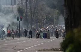 Manifestantes se enfrentan a agentes de policía hoy, en las calles de Quito (Ecuador).  (EFE)