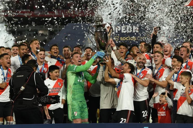 Robert Rojas y Héctor David Martínez festejan con el resto del plantel el título de campeón de Liga Profesional con River Plate.