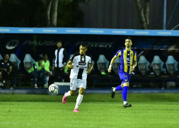 Jorge González se lleva el balón ante la mirada de Matías Castro, de Luqueño