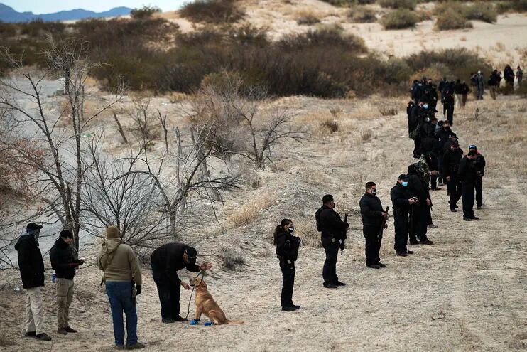 Agentes de la Fiscalía General del Estado de Chihuahua y expertos forenses participan en un operativo de búsqueda de fosas clandestinas en Ciudad Juárez, México.