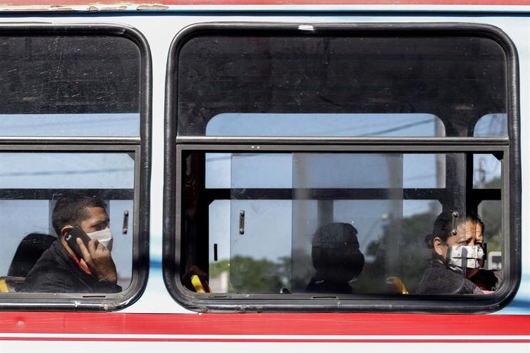 Pasajeros con tapabocas en un transporte público en Asunción.