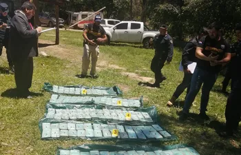 Agentes de Antinarcóticos de la Policía Nacional y el fiscal Erico Ávalos verifican los paquetes de cocaínas incautados del vehículo abandonado en la localidad de Doctor Botrell, departamento de Guairá.