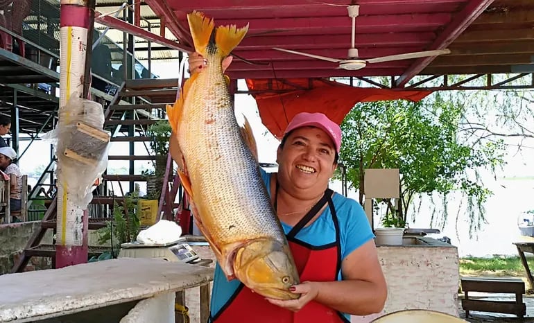 mujer sosteniendo un pescado gande