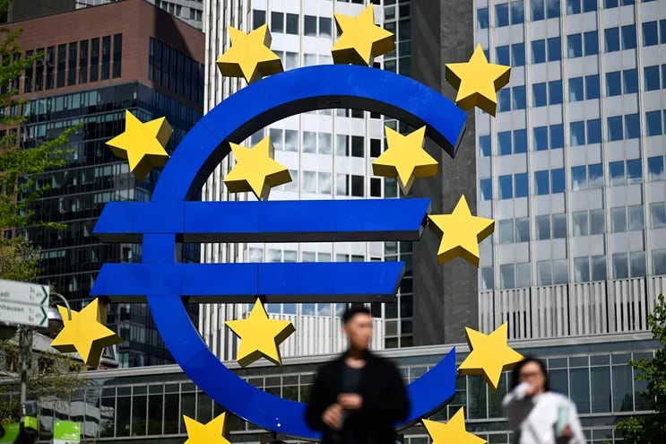 Una pareja pasa junto al logotipo del euro en Frankfurt am Main, Alemania.