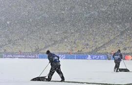 Los auxiliares del Olímpico de Kiev removiendo la nieve del campo.