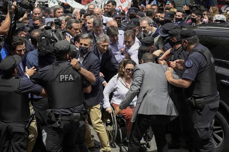El expresidente de Argentina, Mauricio Macri (C) y la expresidenta Gabriela Michetti (en silla de ruedas) llegan al juzgado.