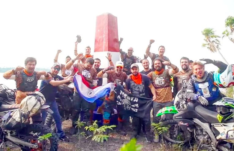 Integrantes de la comitiva de 12 motociclistas con uno de los hitos ubicados en el Chaco.
