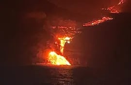 La colada de lava que emerge de la erupción volcánica de La Palma ha llegado al mar en una zona de acantilados.