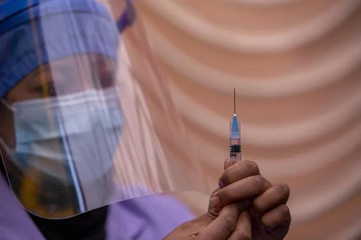 Una enfermera prepara una dosis de la vacuna AstraZeneca para aplicársela a un paciente.