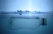 Botella de plástico flotando debajo de una capa de hielo.