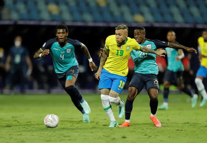 Everton de Brasil disputa el balón con Jhegson Méndez (d) y Robert Arboleda (i) de Ecuador, durante un partido por el Grupo B de la Copa América en el estadio Olímpico Pedro Ludovico Teixeira, en Goiania (Brasil).