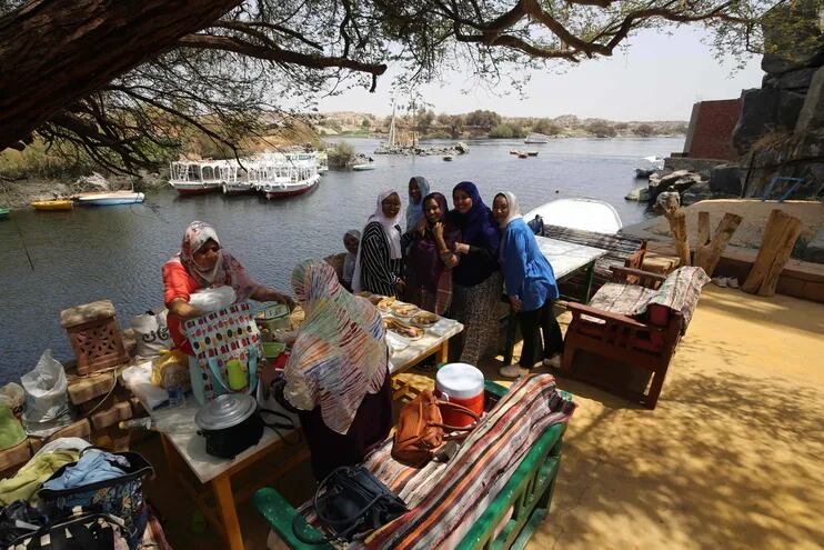 Mujeres sudanesas que huyeron de la guerra en su país comparten una comida a orillas del río Nilo en la ciudad egipcia de Asuán, el 8 de septiembre de 2023.
