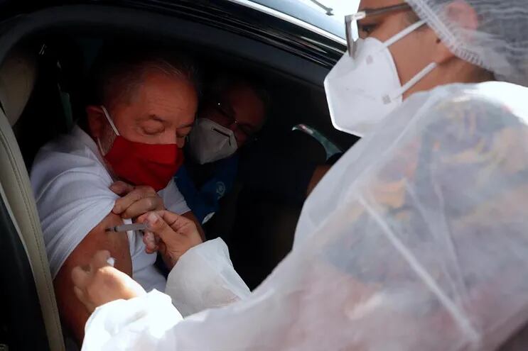 El expresidente Luiz Inácio Lula da Silva es vacunado contra la covid-19 hoy en un centro de autoservicio, en la alcaldía de la ciudad de São Bernardo en São Paulo (Brasil).