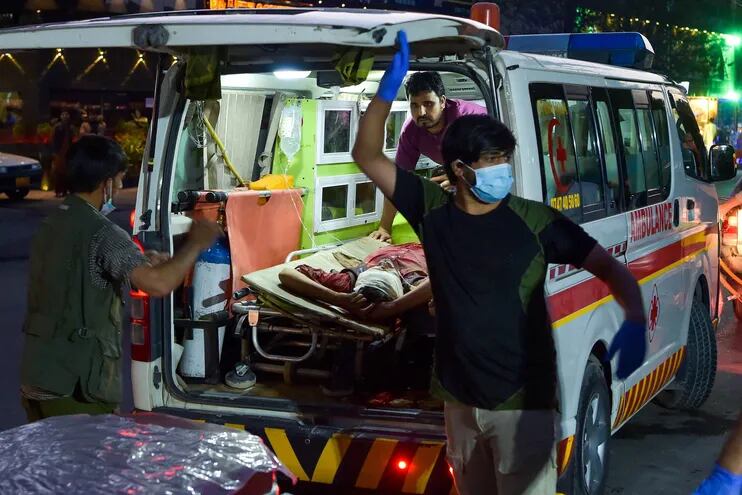 Paramédicos trasladan a un hombre herido luego de las dos explosiones fuera del aeropuerto internacional de Kabul, este jueves.