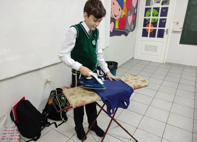 Uno de los alumnos practicando a planchar una ropa durante la clase de Trabajo y Tecnología.