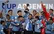 El capitán Fabricio Díaz levanta el trofeo de campeón rodeado de sus compañeros durante el festejo de la selección uruguaya.