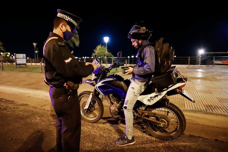Policía verifica permiso de circulación de motociclista, cuando se daban los controles rígidos del Gobierno de posibles violaciones a la cuarentena sanitaria.