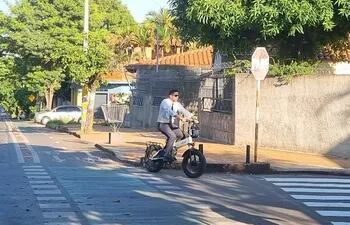 Con corbata y en bicicleta eléctrica este oficinista recorre la bicisenda sobre la calle San Alfonso, en el barrio Mburicaó de Asunción.
