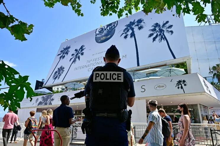 Un policía permanece frente al Palacio del Festival de Cannes, que hoy debió ser evacuado ante la aparición de un paquete sospechoso.