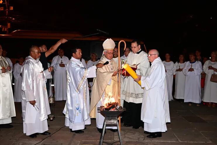 El cardenal Martínez enciende el cirio pascual de la fogata bendecida en el inicio de la Vigilia Pascual.