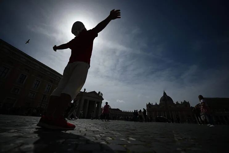 Un turista posa en la plaza de San Pedro, en el Vaticano.