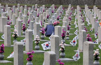 Un visitante presenta sus respetos en la tumba de un soldado caído en el cementerio nacional de Seúl, Corea del Sur, el 25 de junio de 2022, el 72º aniversario del estallido de la Guerra de Corea.