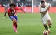El inglés Jude Bellingham (d), del Real Madrid, domina el balón ante el acoso del belga Axel Witsel, del Atlético Madrid, durante el partido disputado ayer en Riad.