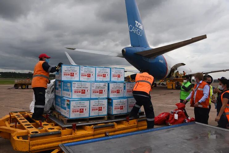 Cajas conteniendo 100.000 dosis de la vacuna Covaxin contra el COVID-19, donadas por la India, desembarcadas por trabajadores del aeropuerto Silvio Pettirossi el lunes 29 de marzo.