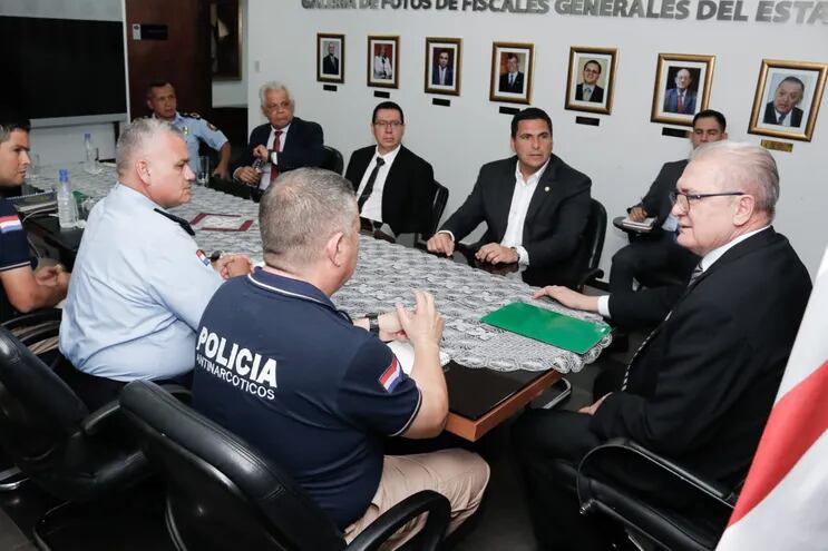 El fiscal general Emiliano Rolón y el titular de la APF Robert Harrison, junto a policías durante la reunión para delinear un mecanismo de combate a la violencia en el fútbol.
