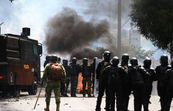 Policías antimotines se enfrentan a manifestantes hoy, en las calles de Quito (Ecuador).