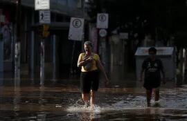Vecinos de Porto Alegre caminan por una zona inundada de la ciudad, el pasado miércoles.