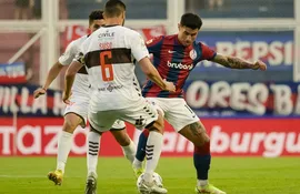 El paraguayo Adam Bareiro (d), jugador de San Lorenzo de Almagro, domina el balón frente a la marca de Gastón Suso, futbolista de Platense, en el partido por la jornada 10 de la Copa de la Liga Profesional de Argentina.