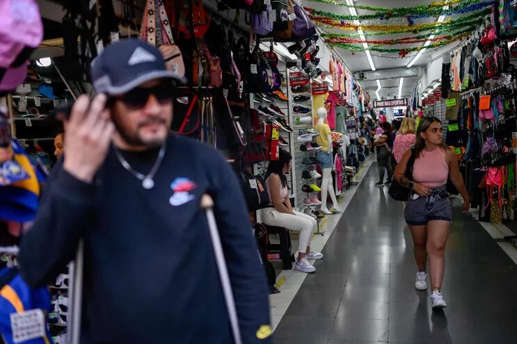 La gente camina por un pasillo en un centro comercial en el centro de Buenos Aires.