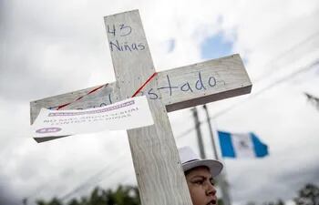 una-mujer-carga-una-cruz-de-madera-como-senal-de-protesta-hoy-jueves-16-de-marzo-de-2017-en-honor-a-las-40-ninas-que-perdieron-la-vida-tras-un-incen-03152000000-1564817.jpg