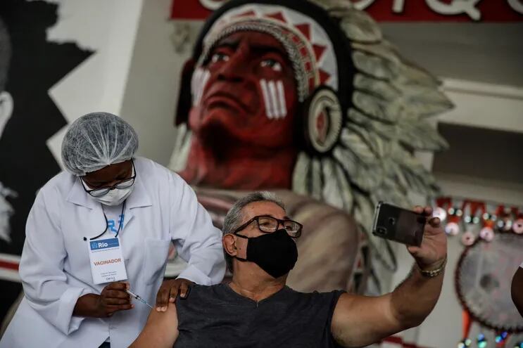 Un hombre recibe hoy, 8 de abril de 2021, una dosis de la vacuna de CoronaVac de Sinovac contra la covid-19 en la cuadra de Cacique de Ramos, una de las comparsas de carnaval más tradicionales de Río de Janeiro, Brasil. (EFE)