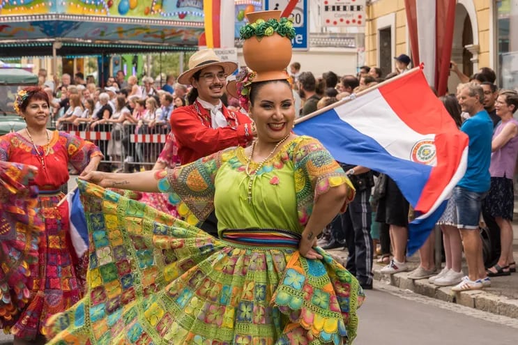 Una mujer con vestimenta tradicional paraguaya y el cántaro en la cabeza.