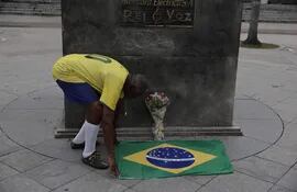 El brasileño Marcio Da Silva rinde tributo a Pelé hoy, frente al estadio Maracaná de Río de Janeiro (Brasil). El brasileño Edson Arantes do Nascimento 'Pelé', considerado por muchos el mejor futbolista de todos los tiempos, murió este jueves a los 82 años, debido a las complicaciones del cáncer que padecía.