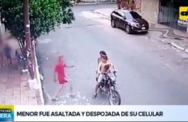 Momento del asalto a una menor. Se observa a una niña que iba en la moto del ladrón. (Captura de ABC TV).