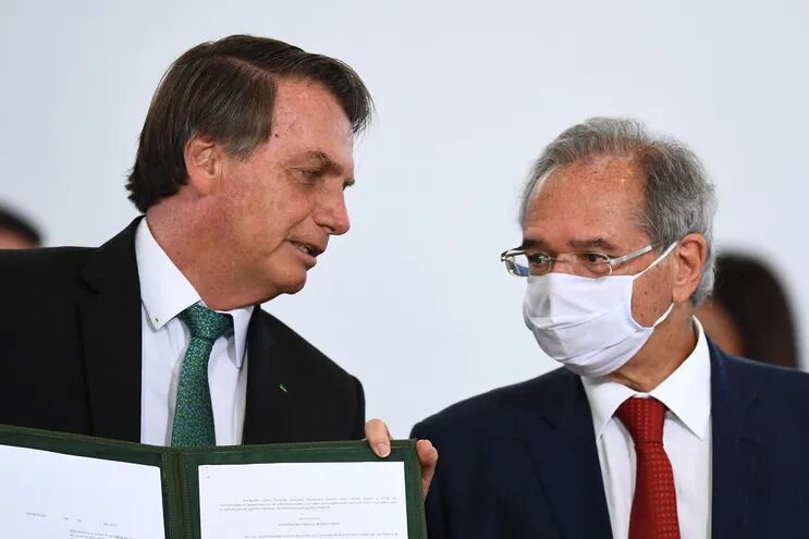 El presidente de Brasil, Jair Bolsonaro (i) y su ministro de Finanzas, Paulo Guedes.