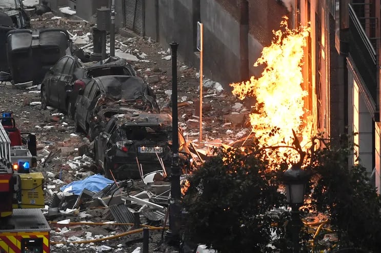 Restos de automóviles, fuera de un edificio dañado en Madrid el 20 de enero de 2021 después de que una fuerte explosión lo sacudiera.