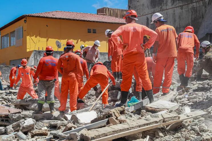 Bomberos trabajan en labores de rescate en el área donde un edificio se desplomó, en Olinda (Brasil).