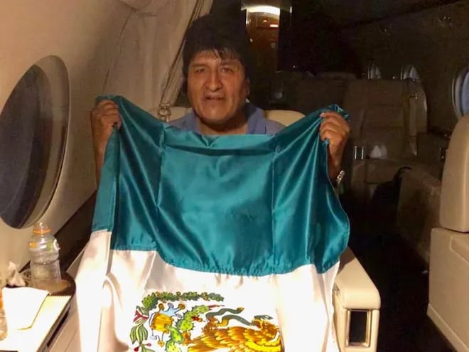 Evo Morales con la bandera de México cuando abordó la aeronave.