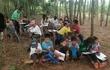 Niños dando clases bajo los árboles