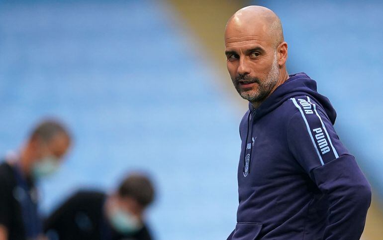 Manchester City's Spanish manager Pep Guardiola reacts in front of empty stands ahead of the English Premier League football match between Manchester City and Arsenal at the Etihad Stadium in Manchester, north west England, on June 17, 2020. - The Premier League makes its eagerly anticipated return today after 100 days in lockdown but behind closed doors due to coronavirus restrictions. (Photo by DAVE Thompson / POOL / AFP) / RESTRICTED TO EDITORIAL USE. No use with unauthorized audio, video, data, fixture lists, club/league logos or 'live' services. Online in-match use limited to 120 images. An additional 40 images may be used in extra time. No video emulation. Social media in-match use limited to 120 images. An additional 40 images may be used in extra time. No use in betting publications, games or single club/league/player publications. / 