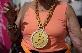Imagen ilustrativa: una mujer con un collar alusivo a la criptomoneda Bitcoin.