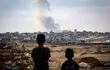 Niños observan una columna de humo sobre Rafah luego de un bombardeo israelí, este lunes.